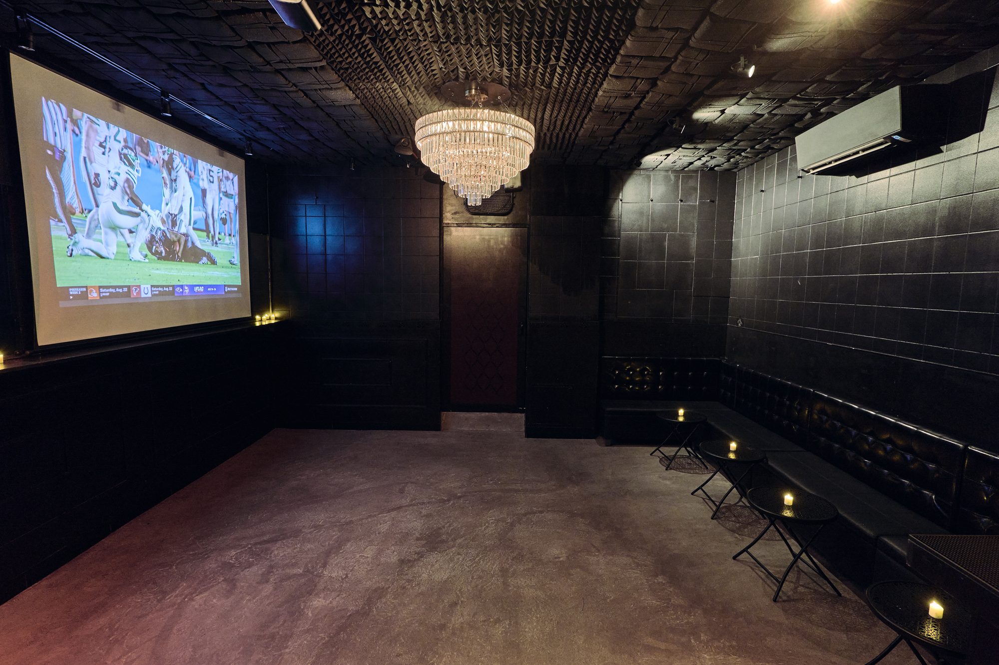 The whole Back Room: projector, chandelier and banquettes