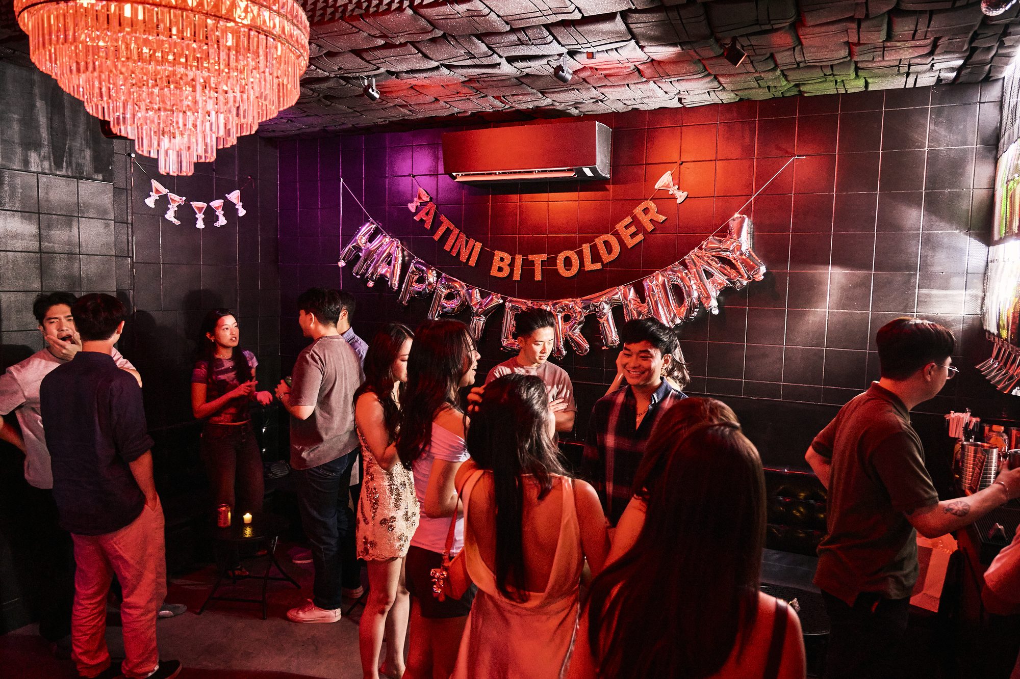 A birthday group under the Back Room chandelier