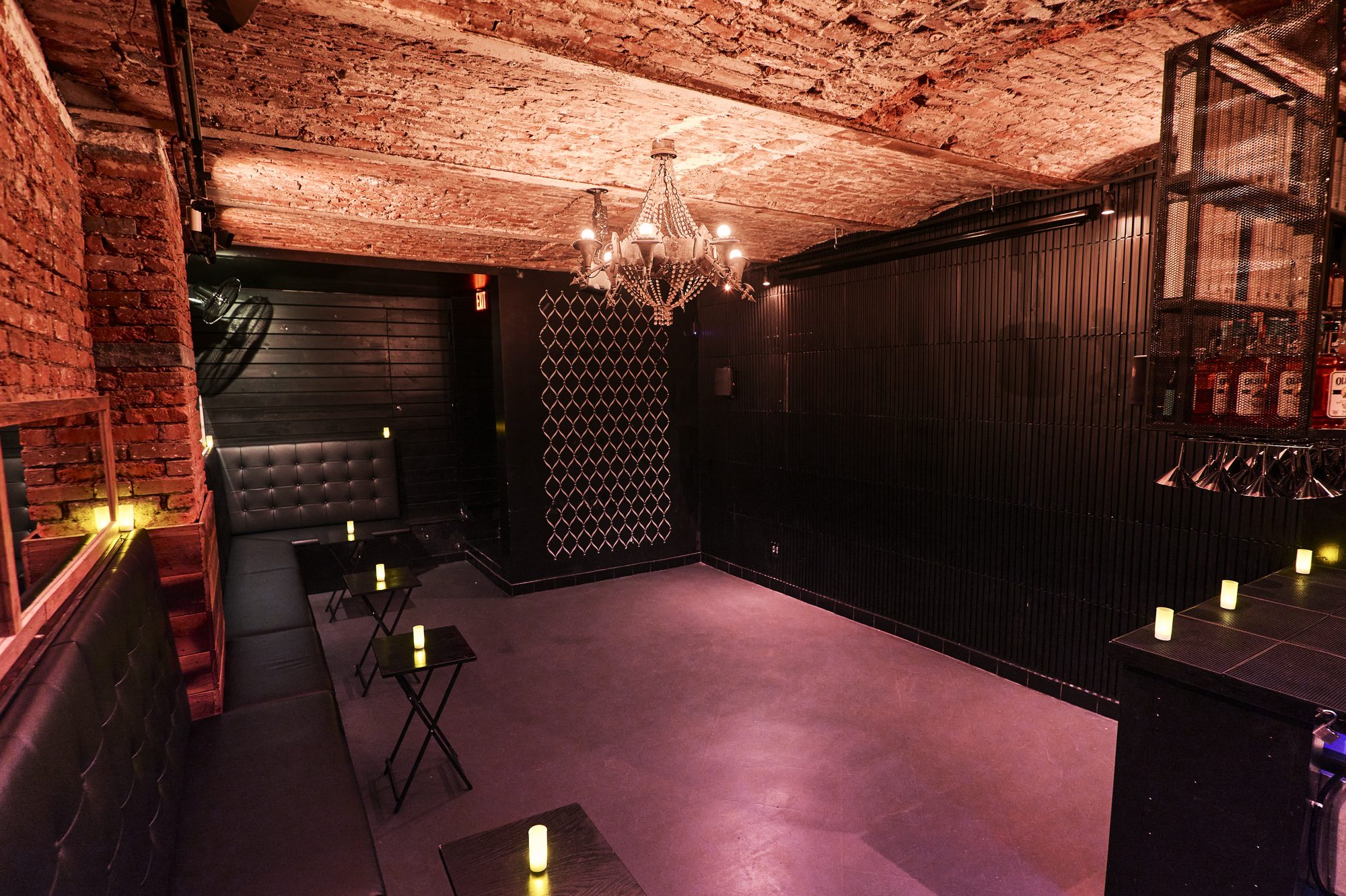 Candlelit tables along the brick wall of the Whiskey Cellar